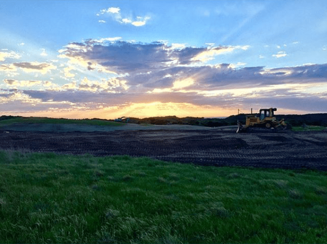 golf architect Michael Henderson on a bulldozer shaping a golf hole